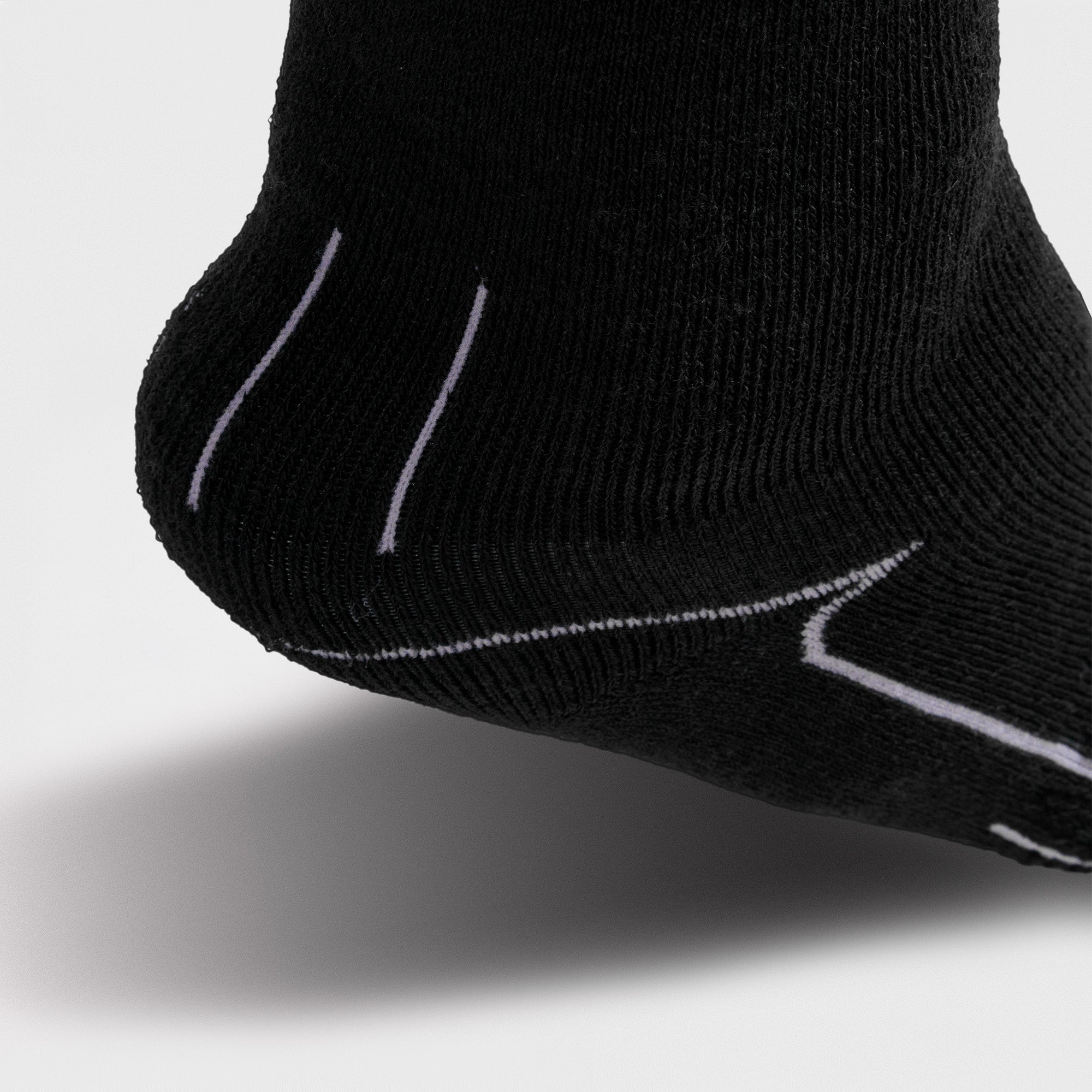 Black ski sock with white stitching on a light gray background