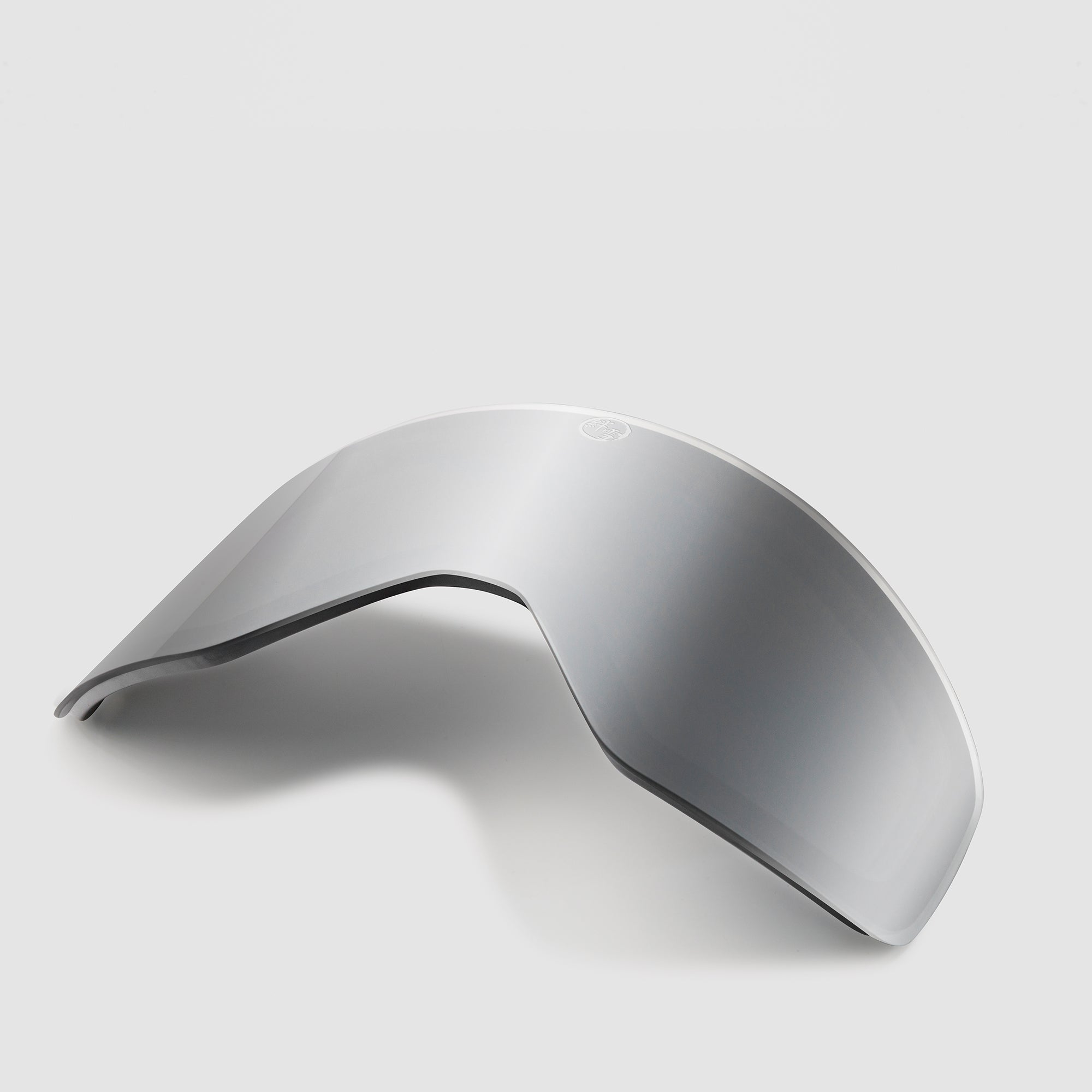 Angled grey ski goggles lens on a light gray background