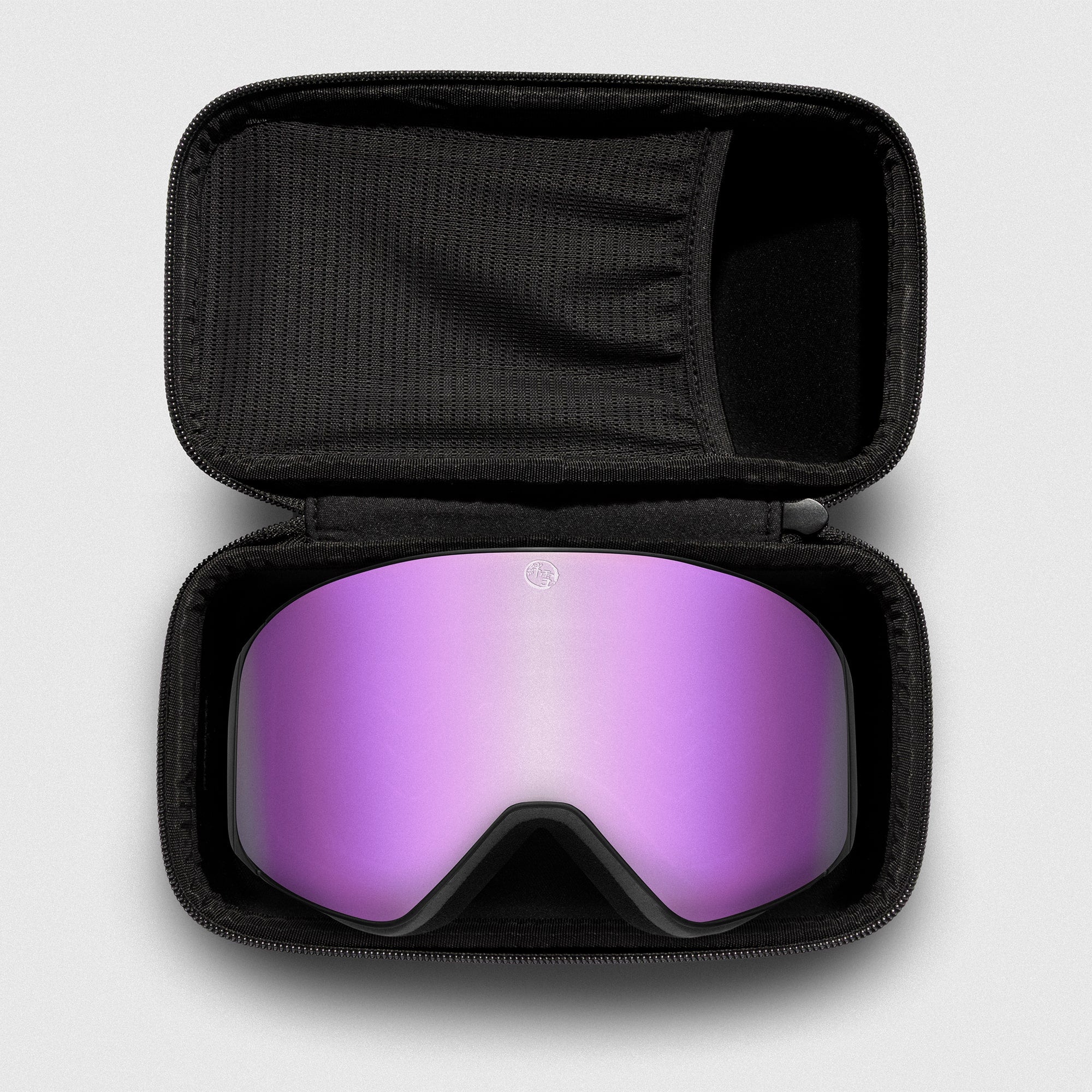 Pink reflective ski goggles, with black frame in a black case on a light gray background
