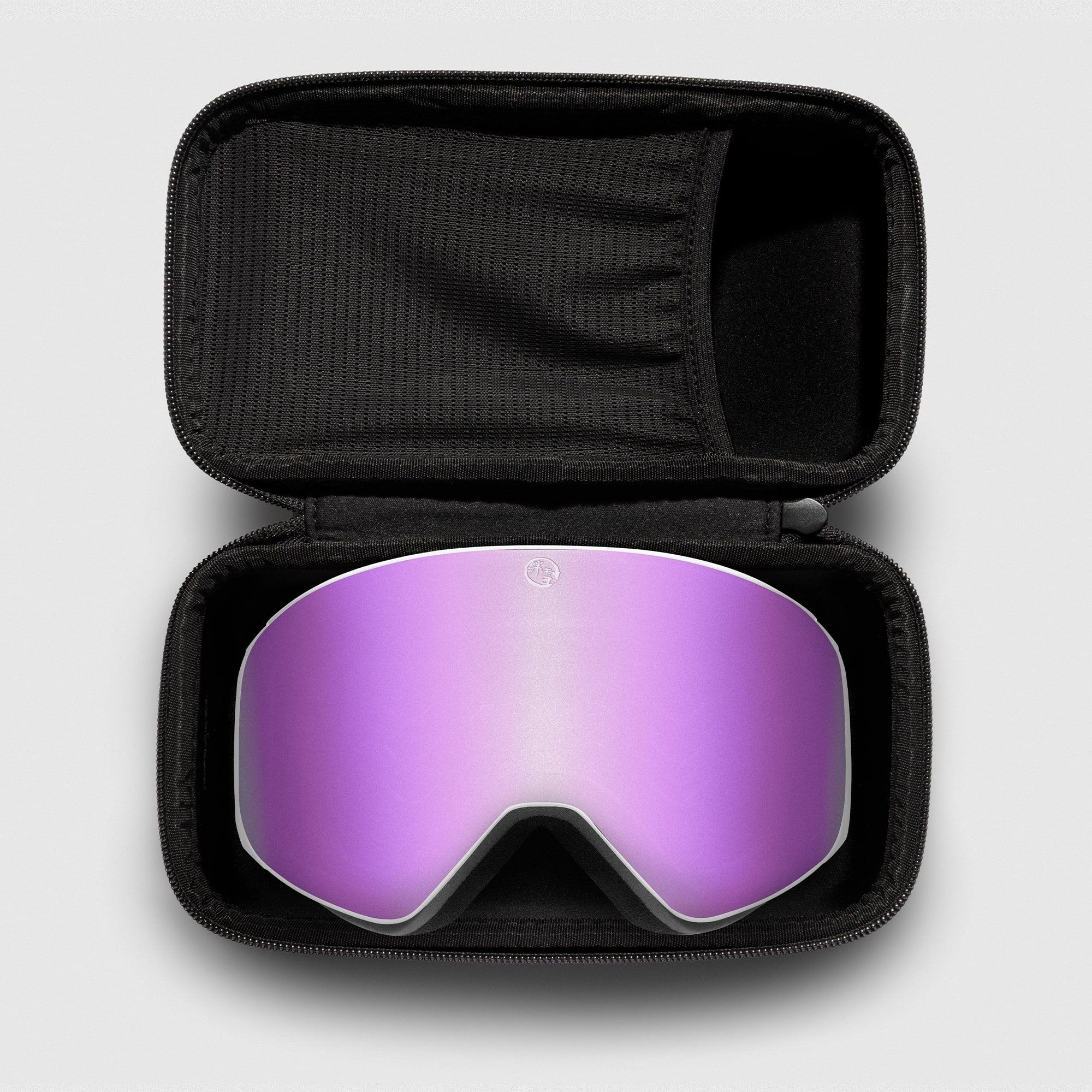 Pink reflective ski goggles, with white frame in a black case on a light gray background