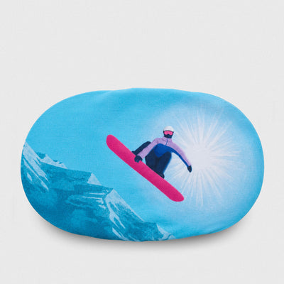 An oval-shaped goggle cover featuring a printed graphic of a snowboarder in mid-air against a bright blue sky with mountains and a sunburst.