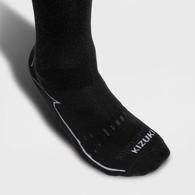 Close-up of a Black ski sock with visible KIZUKI branding on a light gray background