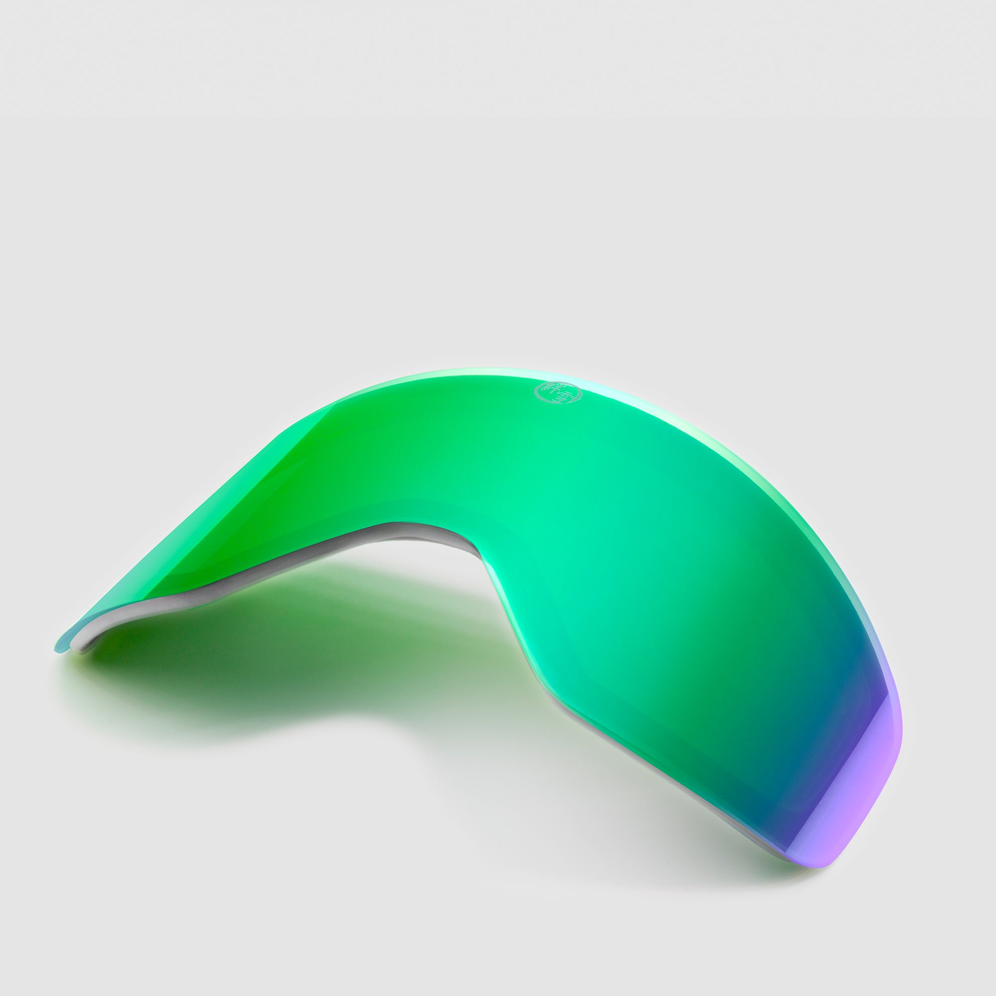 Angled green ski goggles lens on a light gray background